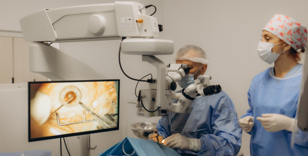 Two medical professionals in blue scrubs examining a computer screen related to glaucoma eye surgery